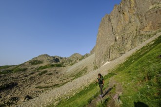 Hiker on the road, Midi d'Ossau peak, 2884 meters, Pyrenees National Park, Pyrenees Atlantiques,
