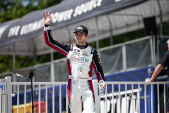 Chandler Smith walks across the stage during driver intros prior to the Road America 180 at Road