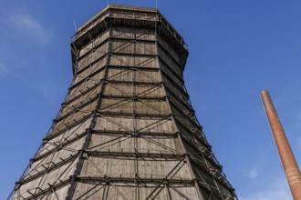 Large wooden cooling tower next to a chimney under a blue sky, Essen, Ruhr area, Germany