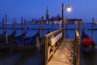 Venetian gondolas, boat dock at St Mark's Square, church of San Giorgio Maggiore in the background,
