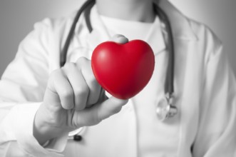 Red heart in the hand of a doctor