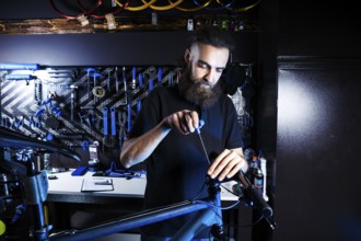 Theme sale and repair of bicycles. Young and stylish with a beard and long hair, a Caucasian man