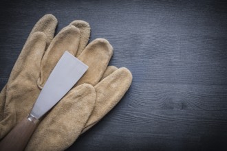 Paint scraper with wood handle and working gloves