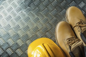 Waterproof boots hard hat on corrugated metal sheet