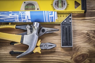 Set of construction tools on wooden board top view