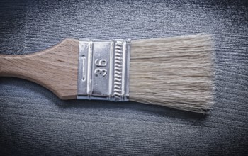 Paintbrush on wooden board close up view construction concept