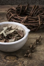 Medicinal licorice rolled in coil and aspen bark on wooden background.selective focus