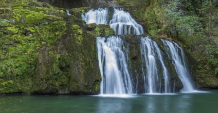 Waterfall from the source of the Lison in a haven of peace with its waterfall surrounded by forest.