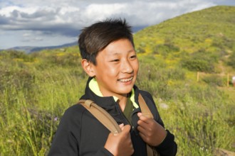 Young sporty Asian boy enjoying and hiking the mountain during the California Golden Poppy and
