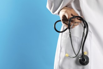 Close-up view of a hospital apron with a stethoscope in his hand