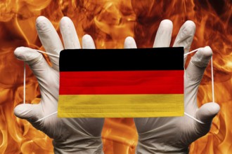 Doctor holding in white gloves protection medical face mask, respiratory bandage with Germany