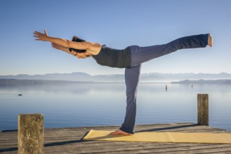 An image of a pretty woman doing yoga at the lake