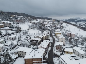 Aerial view of bore, a village in the province of parma covered by snow in december 2024,