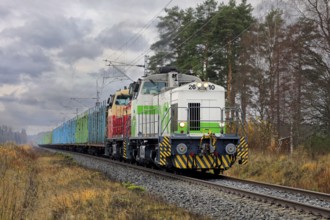 VR freight train with two diesel locomotives and carriages full of wood logs on the move on a day
