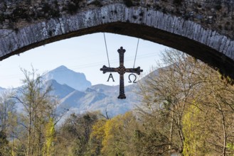 Cross hanging on old Roman stone bridge in Cangas de Onis, Asturias, Spain