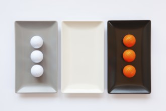 Different ceramic dishes with golf balls on over white background, rectangle dish