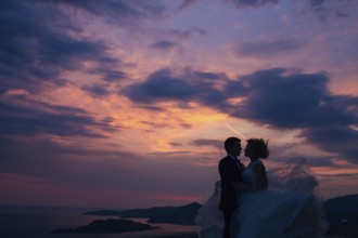 Silhouette of the newlyweds against the sky at sunset. Wedding in Montenegro. Silhouette of a