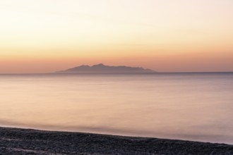 Dawn at sunrise, view from the lava beach near Kamari to the island of Anafi, long exposure, island