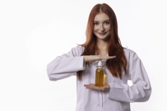 A smiling young woman in a lab coat showcases an innovative hair care product, highlighting beauty