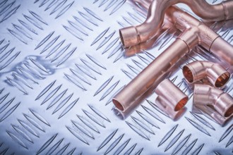 Copper pipe fittings on grooved metal plate plumbing concept