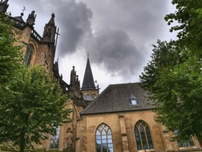 Side view of a Gothic church with cloudy sky and trees, Xanten, North Rhine-Westphalia, Germany