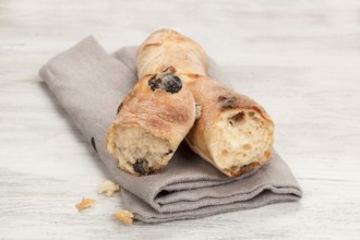 Delicious pastry on wooden table. Olive baguette