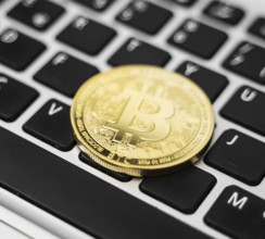 Golden bitcoin coin cryptocurrency on the laptop keyboard