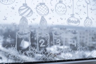 Sustainable responsible holiday decor. Christmas advent candle painted on window glass indoor at