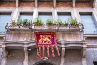 Markuslöwe, Flagge mit dem Wappen von Venedig hängt an einem Erker, Venedig, Italien