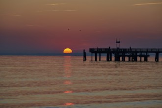 Sunrise over the sea at the pier of the Baltic Sea resort, Boltenhagen, Mecklenburg-Vorpommern,