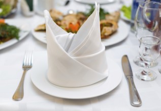 Place setting at laid restaurant banquet table