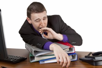 Young businessman yawning at his desk - Freisteller Young businessman yawning at his desk -