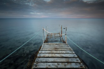 Long wooden pier in the sea at sunset. Protaras Cyprus