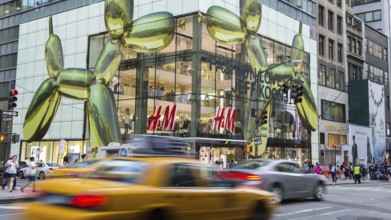 NEW YORK CITY - JULY 29, 2014: Modern HM shop in 5th street New York City with rushing cabs and