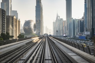 Dubai, UAE - 11.3.2022: Dubai Metro rail with skyscrapers and Museum of the Future in Dubai in the