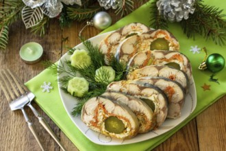 Festive snack. Baked mackerel roll stuffed with cheese, carrots, eggs and pickled cucumber, served