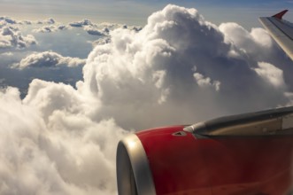 A colour landscape image looking out through airplane window showing land, cloud and sky