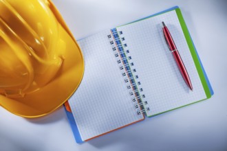 Hard hat notepad pen on white background
