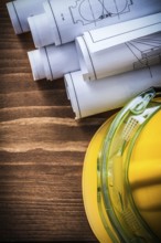 Safety goggles construction drawings and building helmet on wooden background