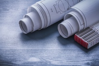 Two rolls of blueprints and white wooden meter