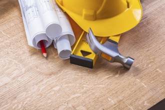 Hardhat level hammer blueprints pencil on wooden boards