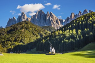 The famous symbol of the valley Val di Funes - church of Santa Maddalena. Rocky peaks and forested