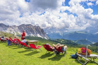 Hikers resting in deckchairs with a beautiful view in the Alps