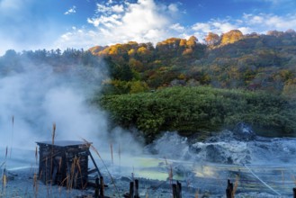 View in Tamagawa onsen in the morning with sunlight shine on the colorful autumn foliage forest on