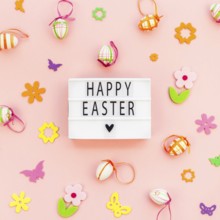 Creative Top view flat lay holiday composition Happy Easter text on lightbox pink paper background