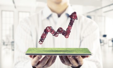 Close of businessman holding tablet with progressing graph. Mixed media