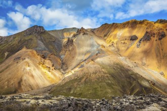 Multi-colored mountains from rhyolite are lit with the July sun. Travel to Iceland in the summer.