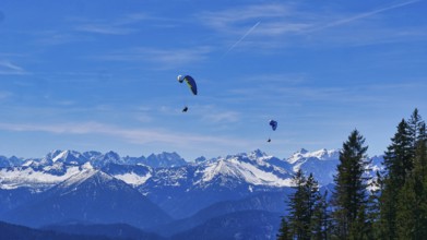 Paragliders on the Brauneck with a view of the Alps
