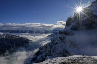 Rays of sunshine over snow-covered mountains and fog in the distance, Valais, Switzerland