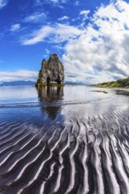 Ocean tide at sunset. The north coast of Iceland. Rock Hvitserkur on the sea beach in the form of a